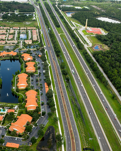Aerial view of a highway with houses on the left side